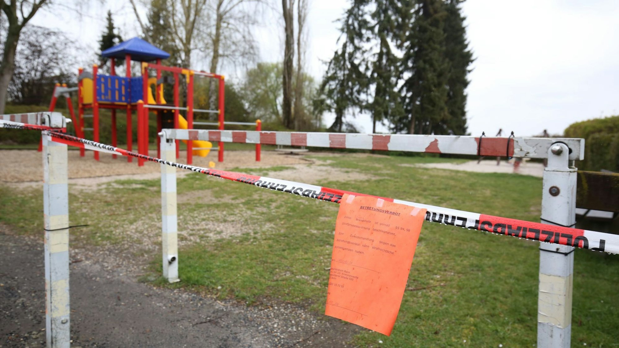 Vor einem Spielplatz ist ein Absperrband gespannt.