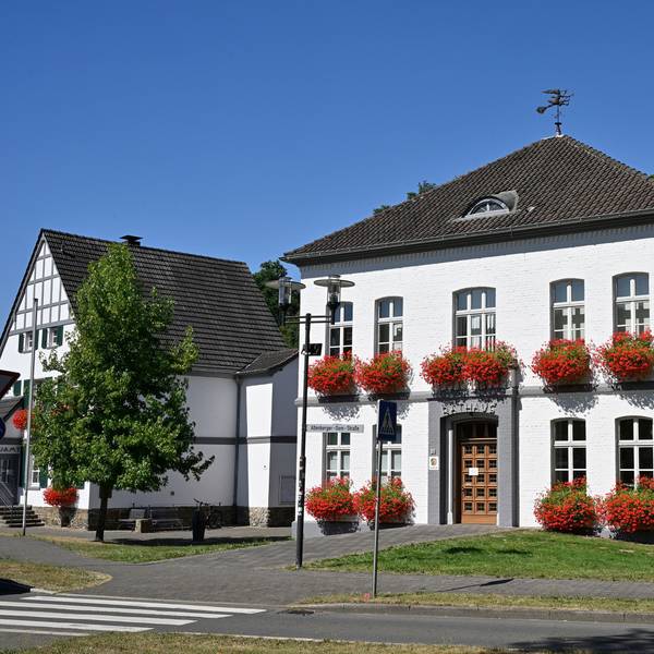 Rathaus Odenthal steht vor Bäumen.