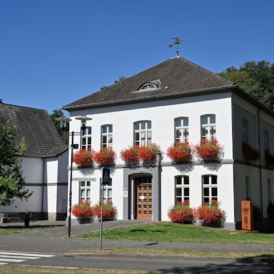 Rathaus Odenthal steht vor Bäumen.