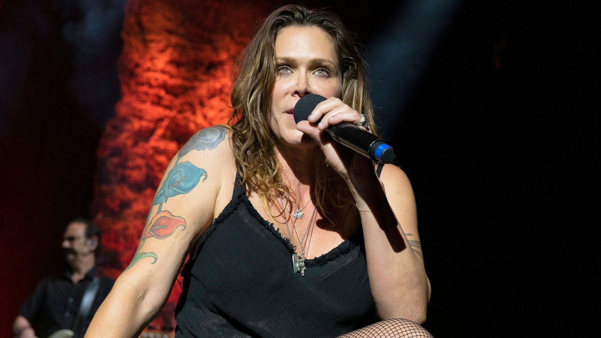 Beth Hart sitzt singend bei einem Konzert auf der Bühne.