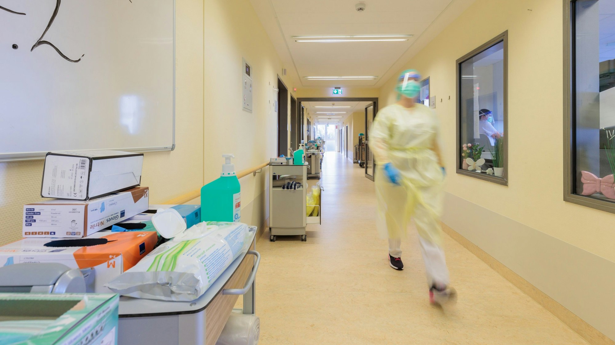Eine Pflegekraft läuft über einen langen Flur.