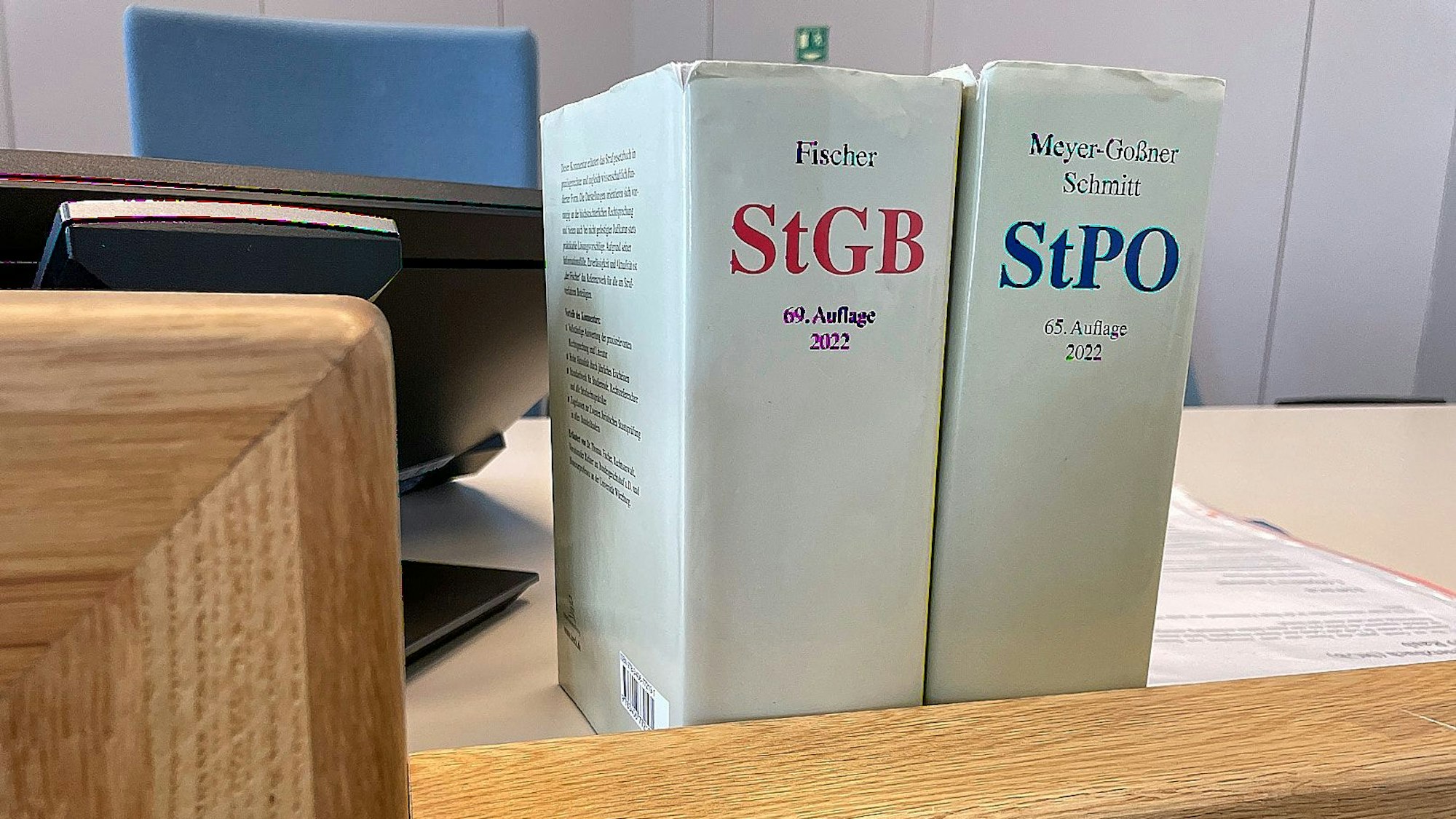 Das Bild zeigt Gesetzbücher auf dem Richtertisch eines Gerichts.
