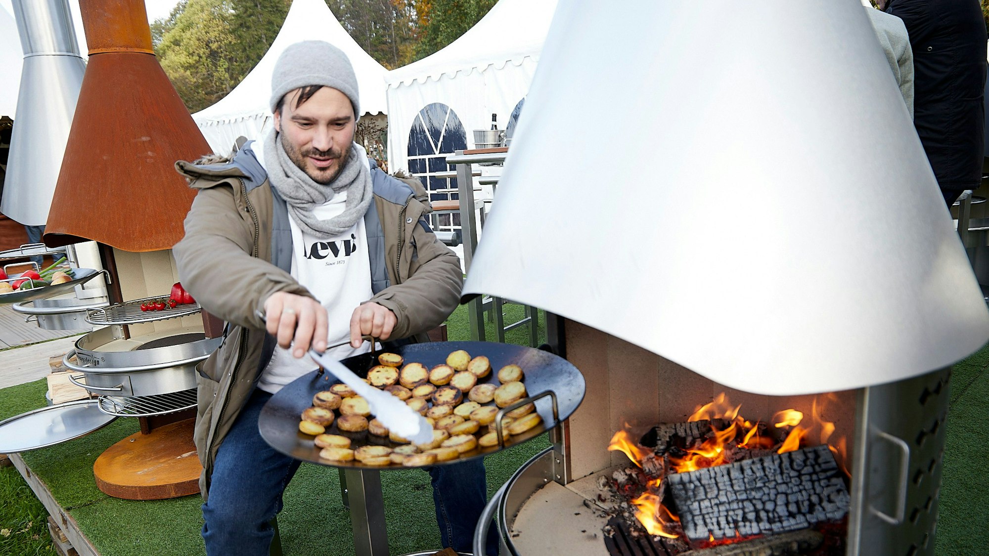 Während die Holzstücke im Kamin lodern, schwenkt Nils Pohl in einer Grillpfanne seine Kartoffelplätzchen.