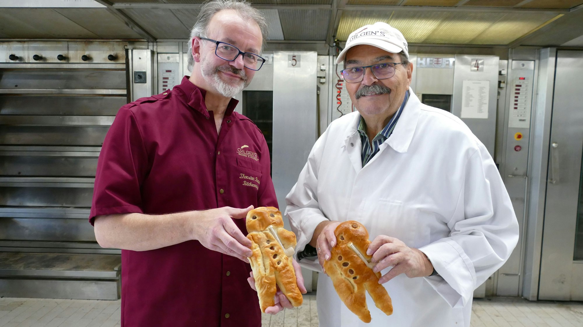 Zwei Bäcker zeigen die fertigen Weckmänner.