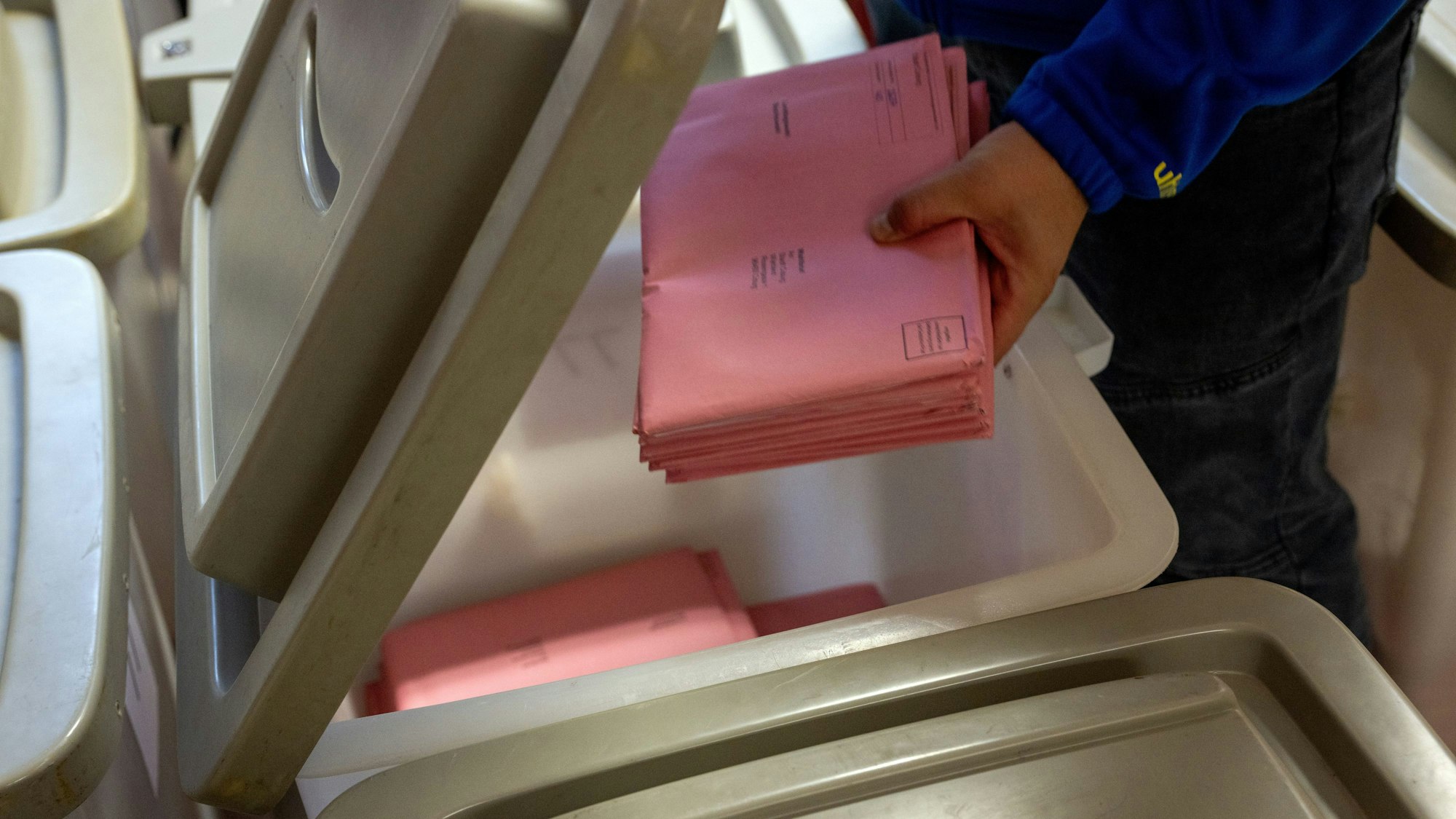 Wahlbriefe werden in Vorbereitung der Auszählung auf die einzelnen Urnen der Briefwahllokale verteilt.