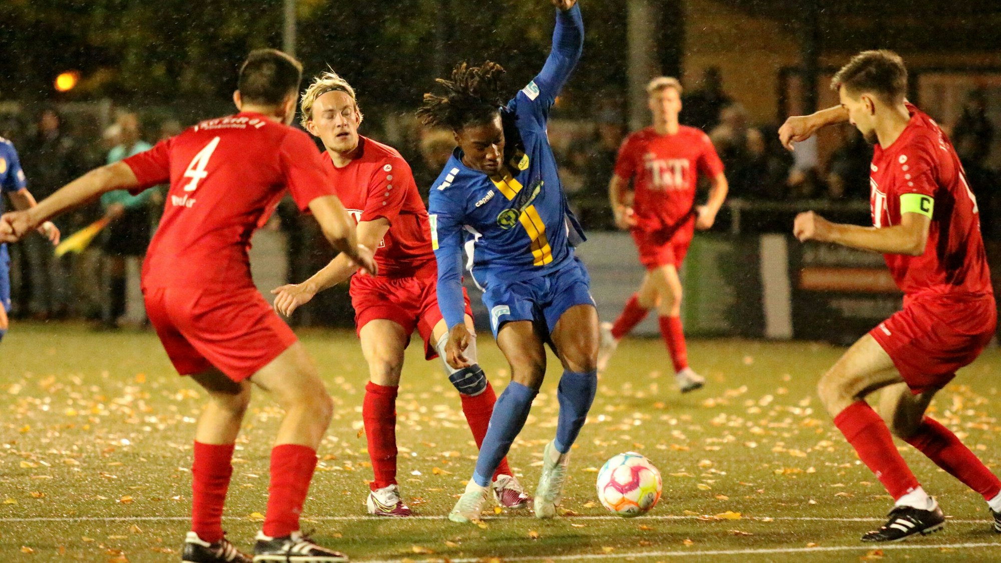 Das Bild zeigt mehrere Spieler der JSG Erft, die versuchen, den Dürener Romeo Aigbbekaen zu stoppen.