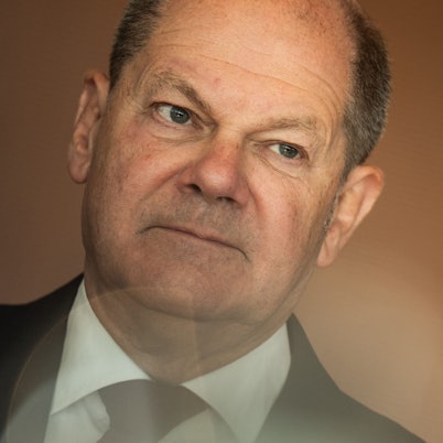 Nahaufnahme des Gesichts von Bundeskanzler Olaf Scholz (SPD) mit Linseneffekt am unteren Bildrand