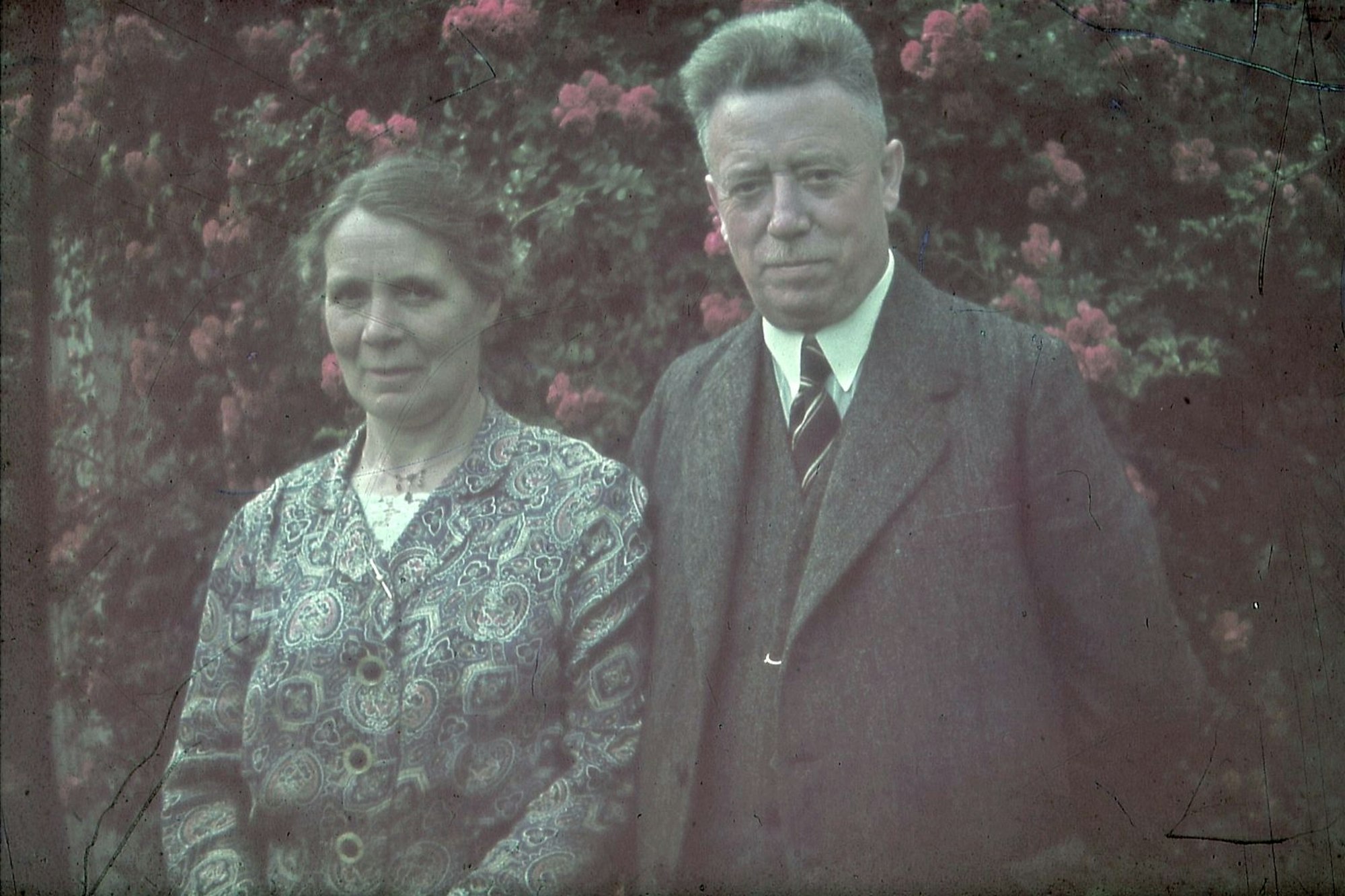 Ein Paar schaut auf dieser nachkolorierten Aufnahme in die Kamera.