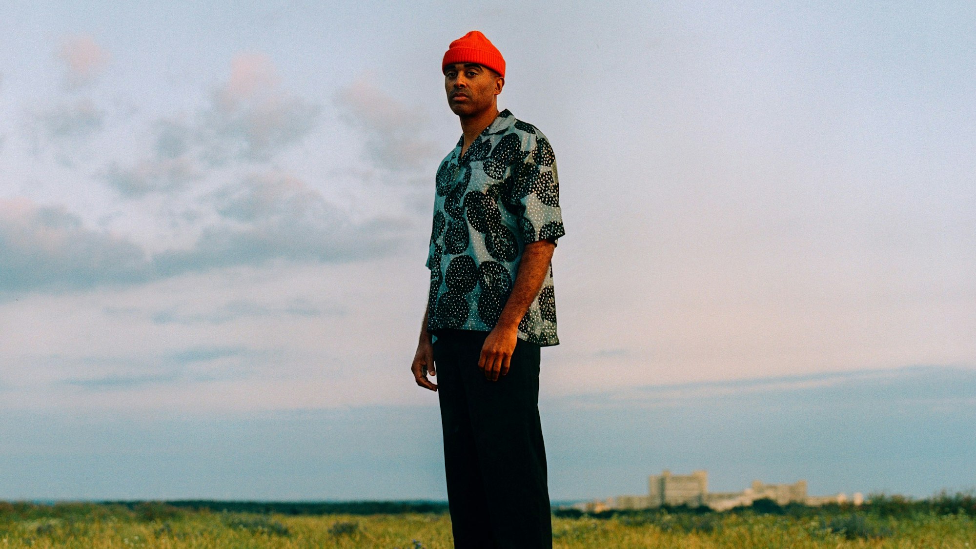 Patrice steht auf einer Wiese.