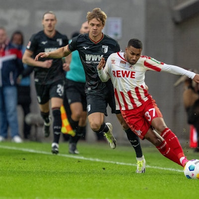 Kölns Linton Maina (r) im Zweikampf mit Augsburgs Robert Gumny.
