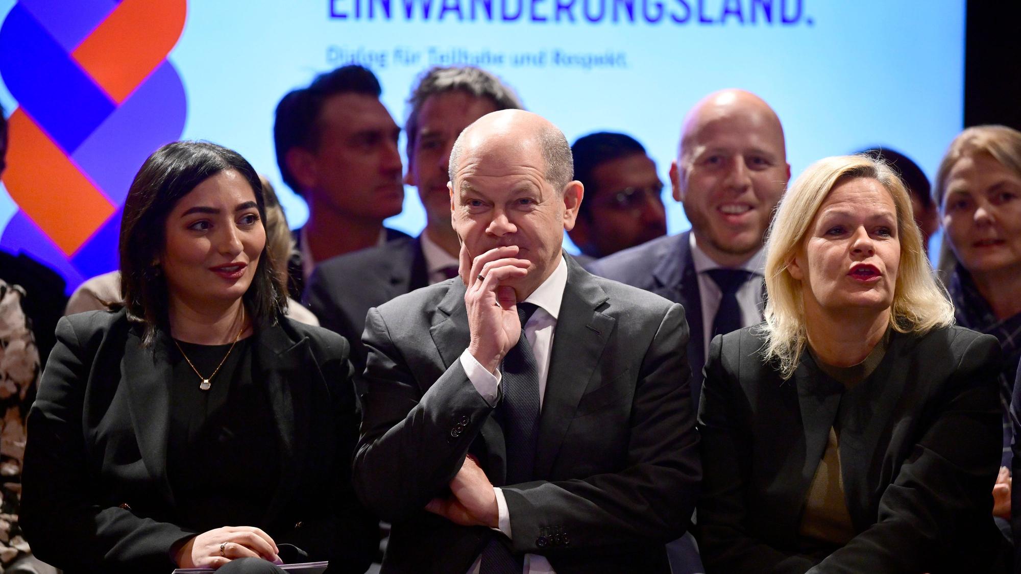 Die Integrationsbeauftragte der Bundesregierung, Reem Alabali-Radovan steht neben Bundeskanzler Olaf Scholz und Innenministerin Nancy Faeser.