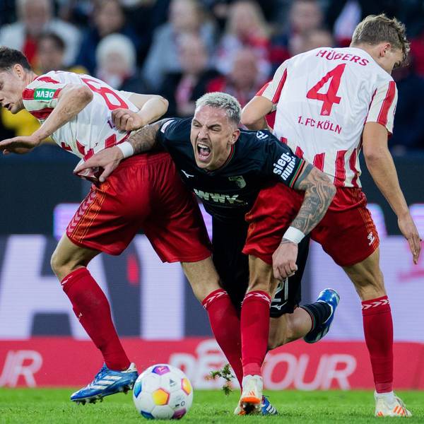 Kölns Eric Martel (l) und Timo Hübers (r) nehmen Augsburgs Torschützen Philipp Tietz in die Zange.