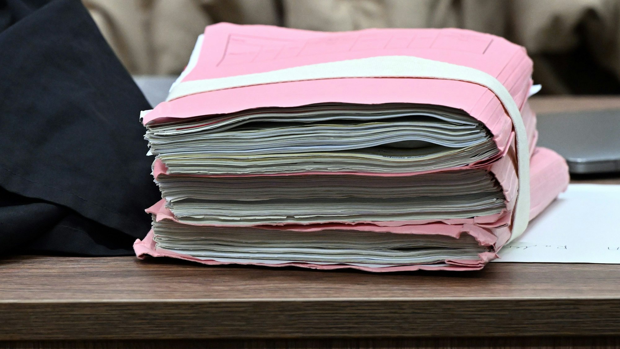 02.11.2023, Nordrhein-Westfalen, Köln: Prozessakten liegen auf dem Tisch einer Rechtsanwältin. Fünf Polizeibeamte stehen unter anderem wegen gemeinschaftlicher gefährlicher Körperverletzung im Amt vor dem Kölner Landgericht. Die Männer im Alter zwischen 25 und 42 Jahren sollen bei einem Einsatz im Stadtteil Bickendorf im Oktober 2019 einen Mann zu Boden gebracht und ihn geschlagen und getreten haben. Foto: Federico Gambarini/dpa +++ dpa-Bildfunk +++