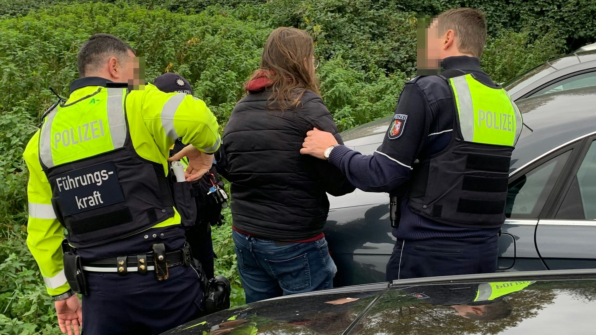 Die Polizei befragt einen Demonstranten aus der Gruppe der Linken nach seinen Personalien.