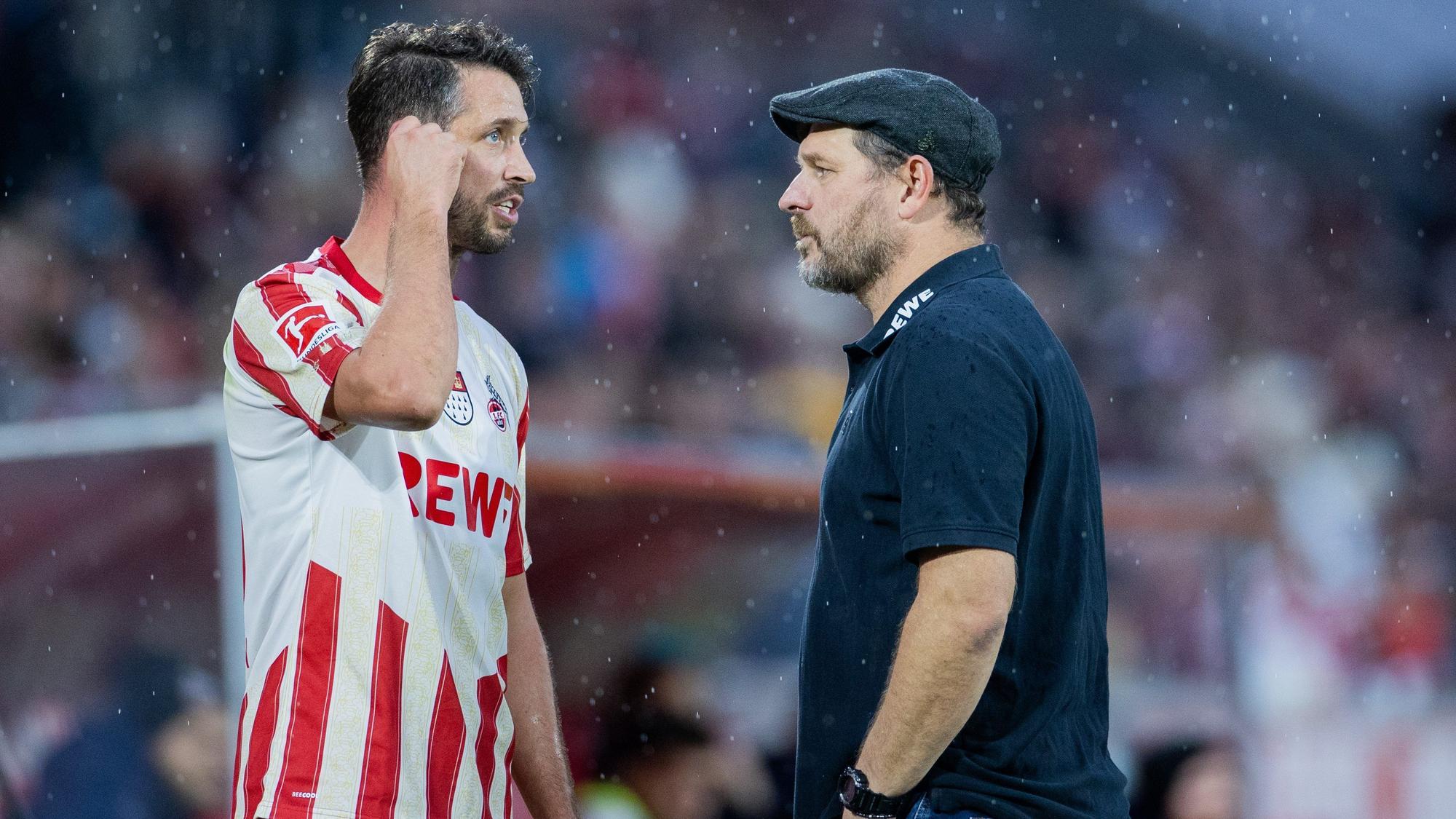 Kölns Mark Uth (l) und Trainer Steffen Baumgart sprechen sich ab.