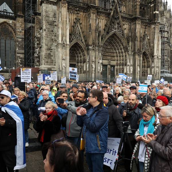 Menschen stehen mit Israel-Flaggen vor dem Kölner Dom.