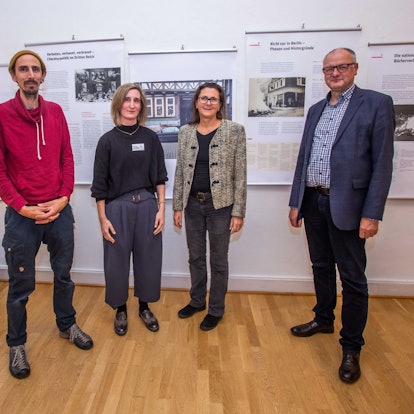 Das Foto zeigt vier Personen vor den Tafeln einer Ausstellung zum Thema Bücherverbrennung