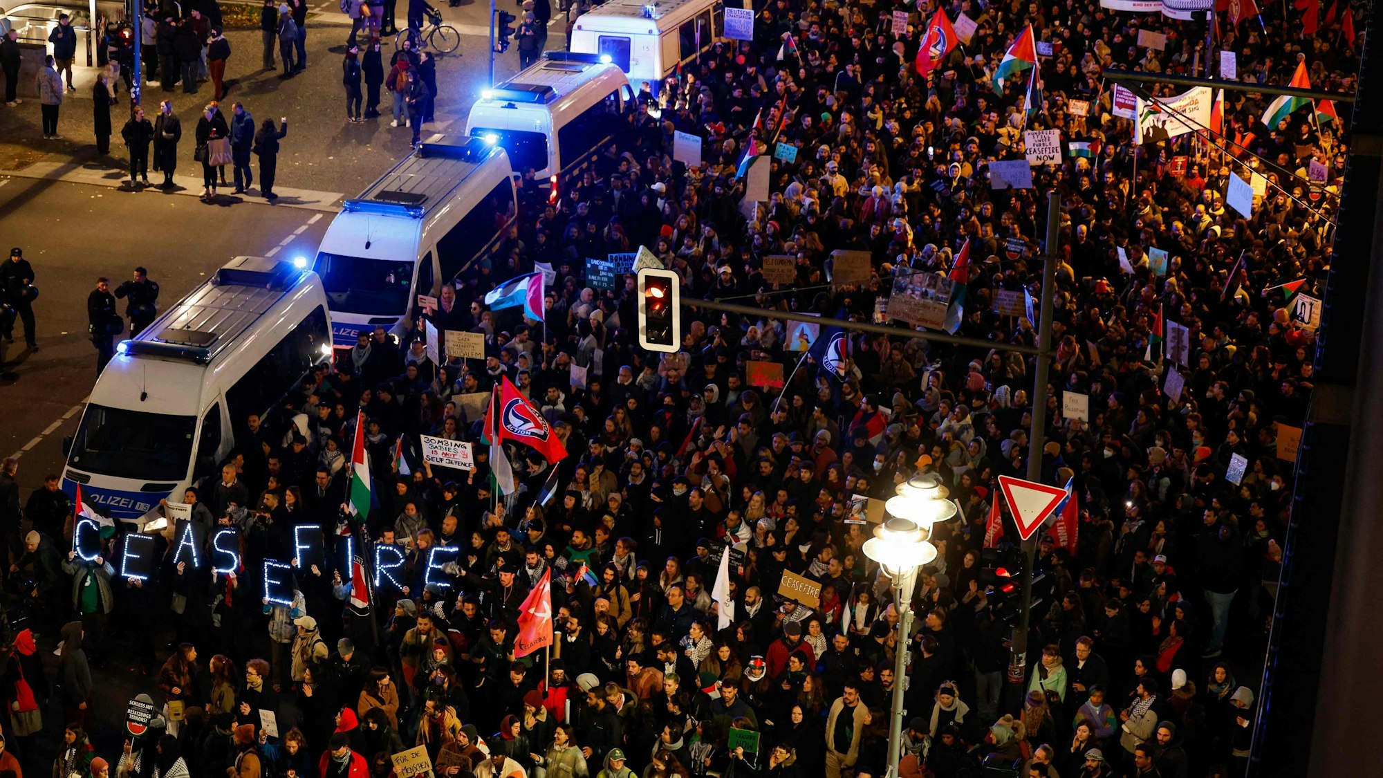 Demonstranten tragen ein Schild mit der Aufschrift „Waffenstillstand“ während einer Protestkundgebung zur Unterstützung der Palästinenser unter dem Motto „Freies Palästina“, als sie eine von Polizeiwagen gesperrte Straße in Berlin passieren.