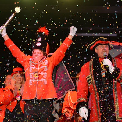 Das Bild zeigt den neuen Regenten, wie er beide Arme in die Luft reckt. Über ihm geht ein Konfettiregen herab.