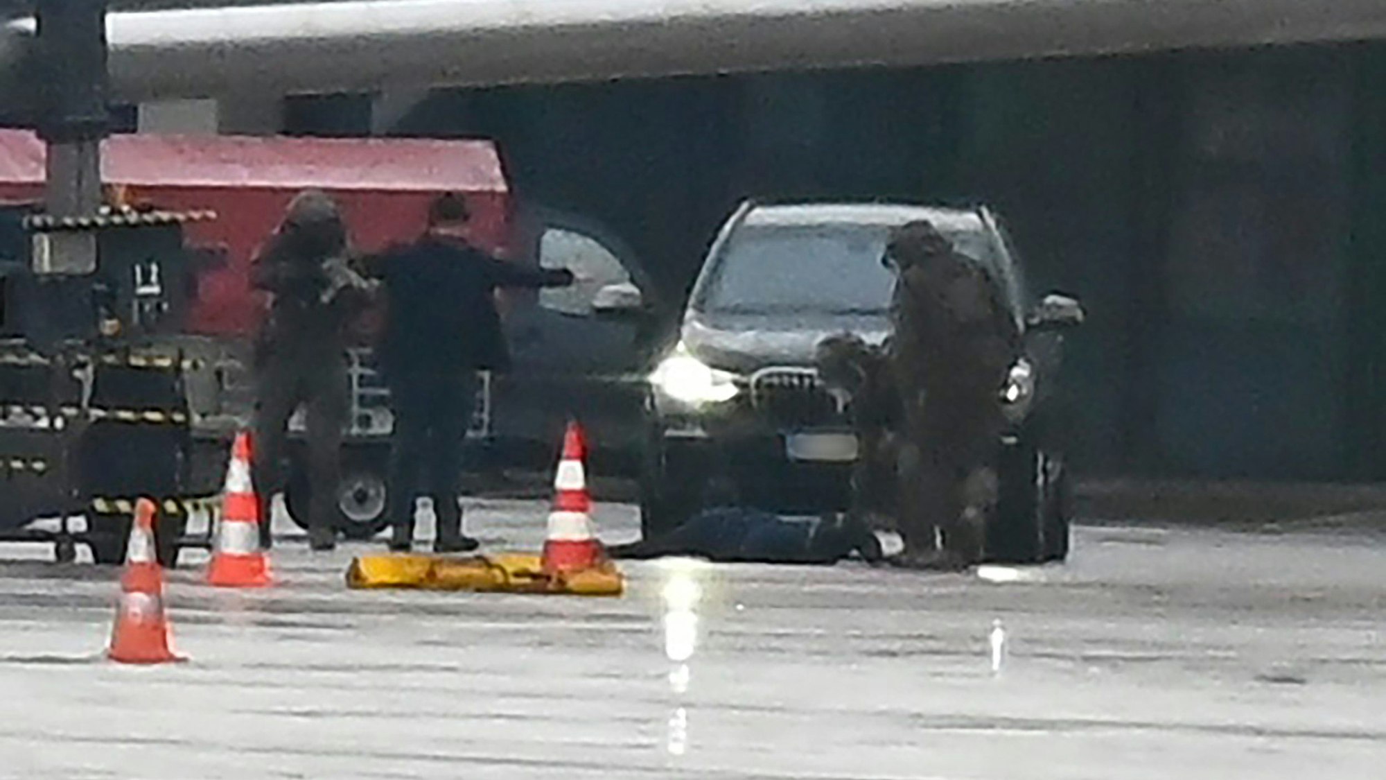 Ein Mann liegt auf dem Flughafen auf dem Boden, umringt von Polizeikräften (Screenshot aus einem Video). Ein bewaffneter Mann hatte auf dem Airport seine vierjährige Tochter in seiner Gewalt gehalten.