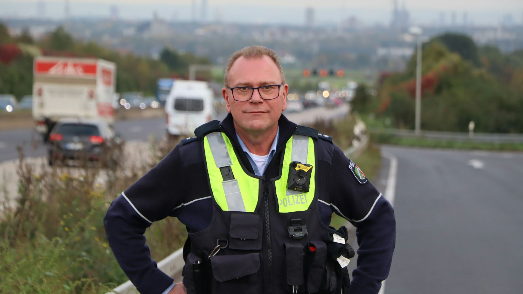 Ein Polizist steht an einer Aufobahnzufahrt.