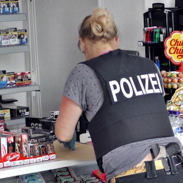 Eine Polizeibeamtin sichert in einem Kiosk Spuren