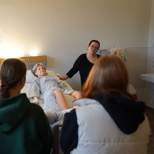 Pflegepädagogin Miriam Strauch zeigt Schülerinnen anhand der Übungspuppe Terry, was in ihrem Beruf wichtig ist.