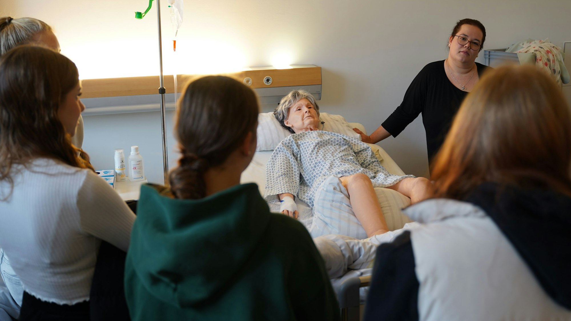 Pflegepädagogin Miriam Strauch zeigt Schülerinnen anhand der Übungspuppe Terry, was in ihrem Beruf wichtig ist.