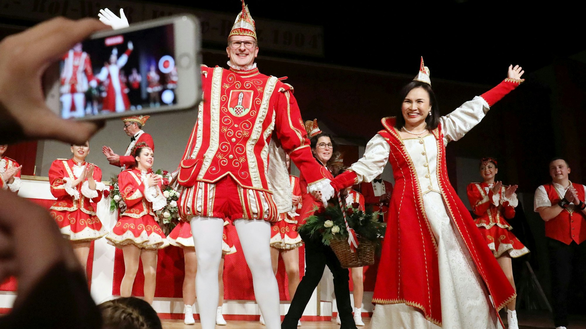 Das neue Prinzenpaar der KG Klääv-Botz Aegidienberg in den Farben Rot und Weiß lässt sich auf der Bühne im Bürgerhaus feiern.