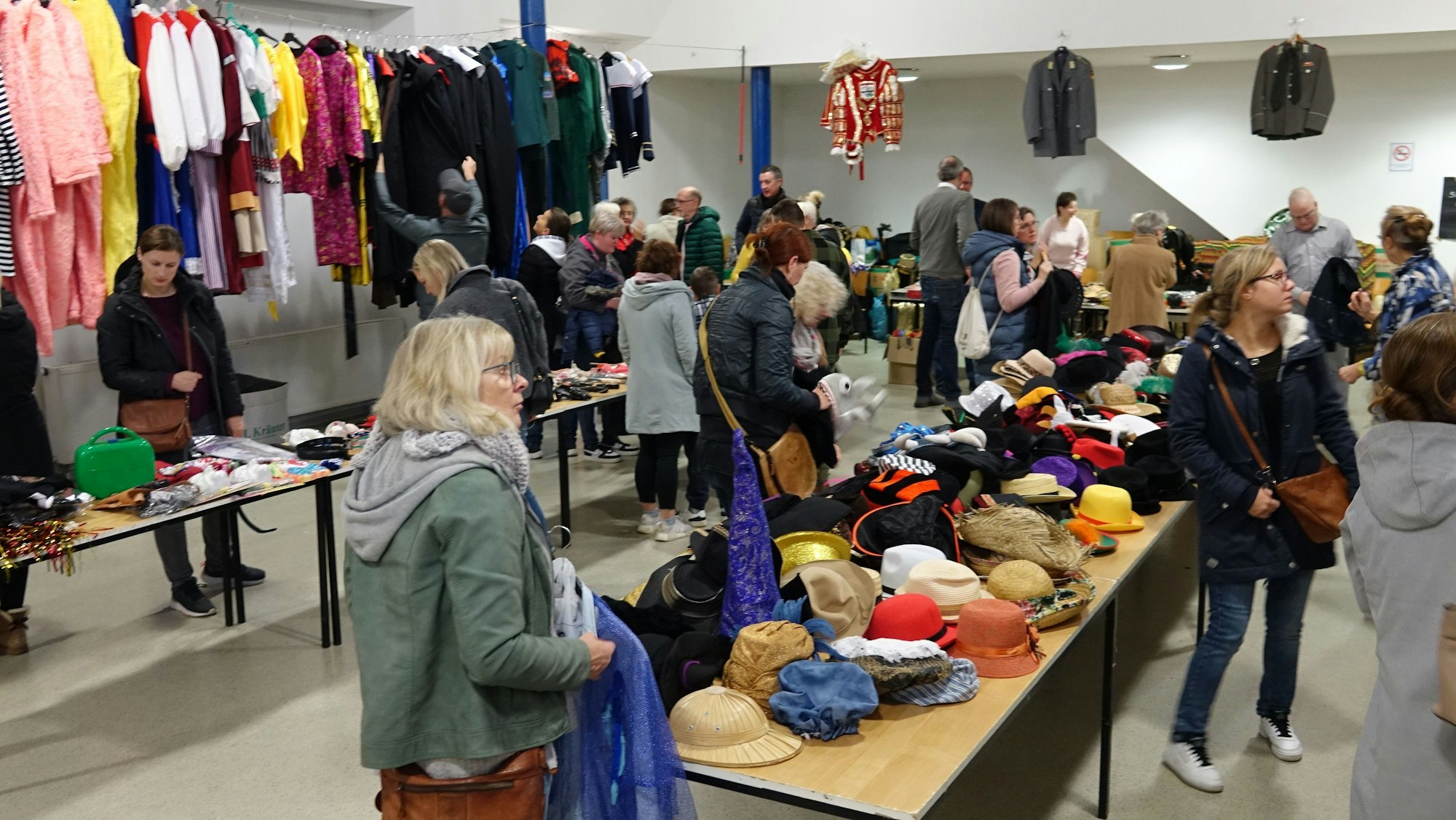 An den Wänden des Pfarrer-Rupprechts-Saales in Siegburg hingen die Kostüme, auf den Tischen lagen unzählige Kopfbedeckungen und Accessoires. Die Besucher stöberten darin herum.