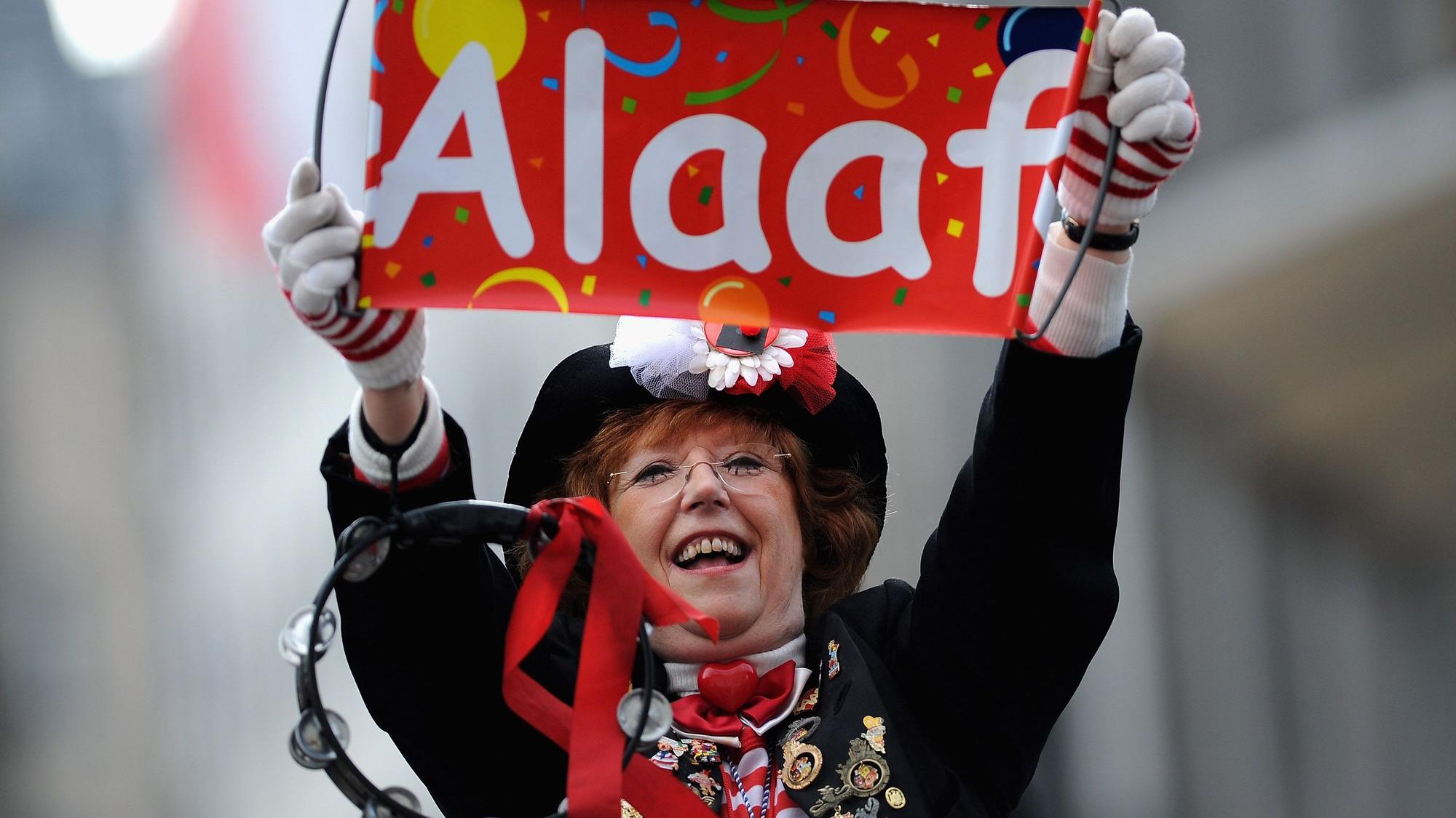 Frau hält ein Schild mit Alaaf im Kölner Karneval hoch