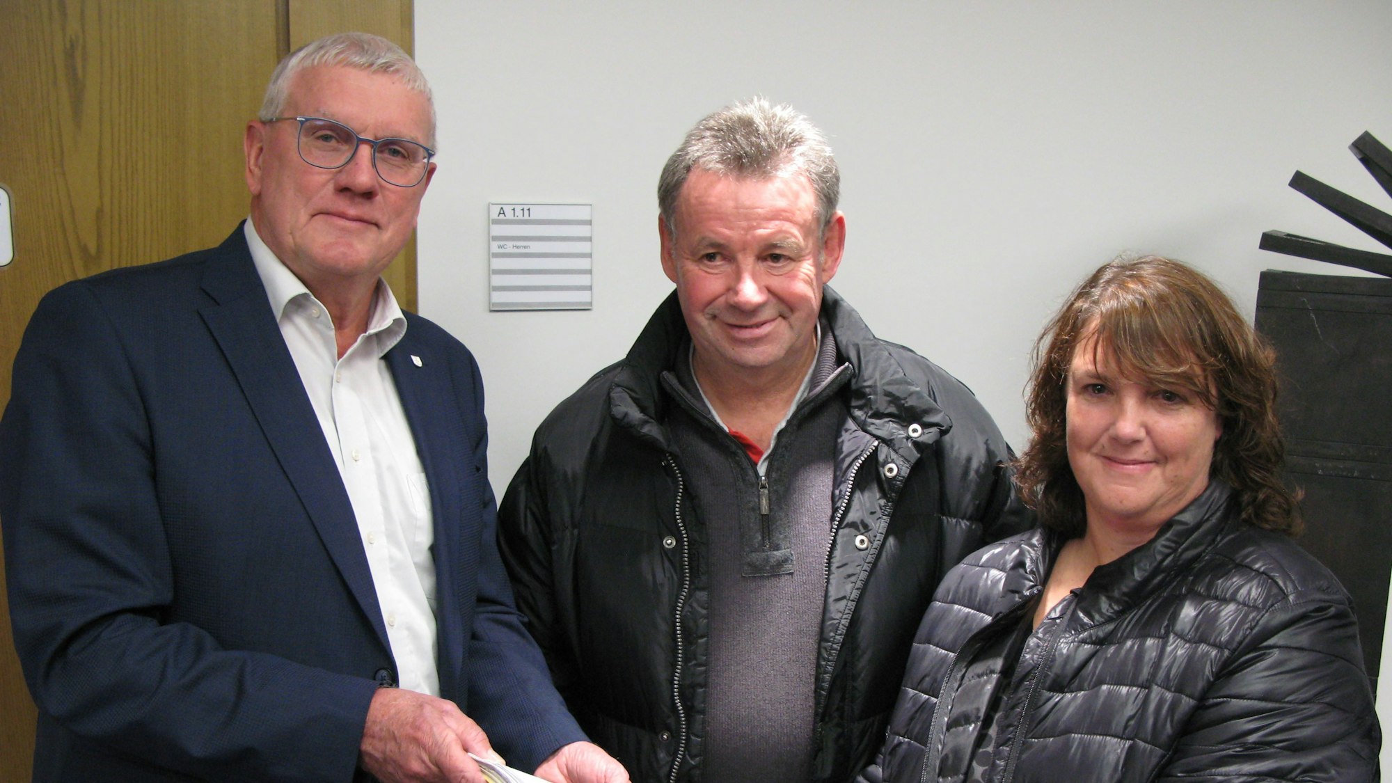 Das Ehepaar Rolf und Birgit Boddenberg übergibt die gesammelten Protest-Unterschriften in einem gelben Heft an Landrat Sebastian Schuster.