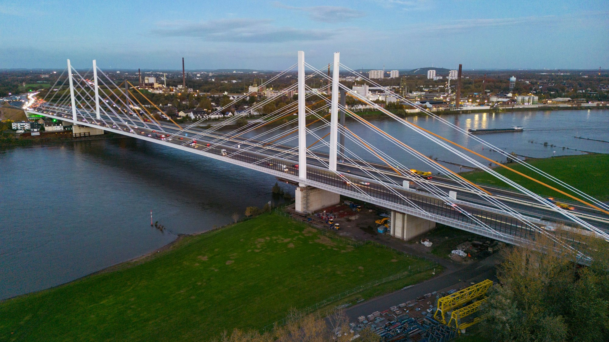 Fahrzeuge fahren am Montagmorgen mit eingeschalteter Beleuchtung über die neue Rheinbrücke, dahinter die alte Rheinbrücke, die nun nicht mehr in Betrieb ist.