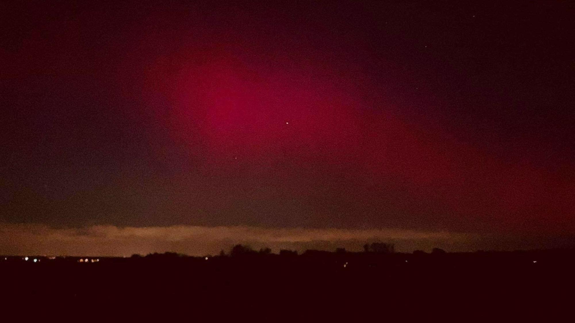Das Bild zeigt rote Nordlichter am Himmel