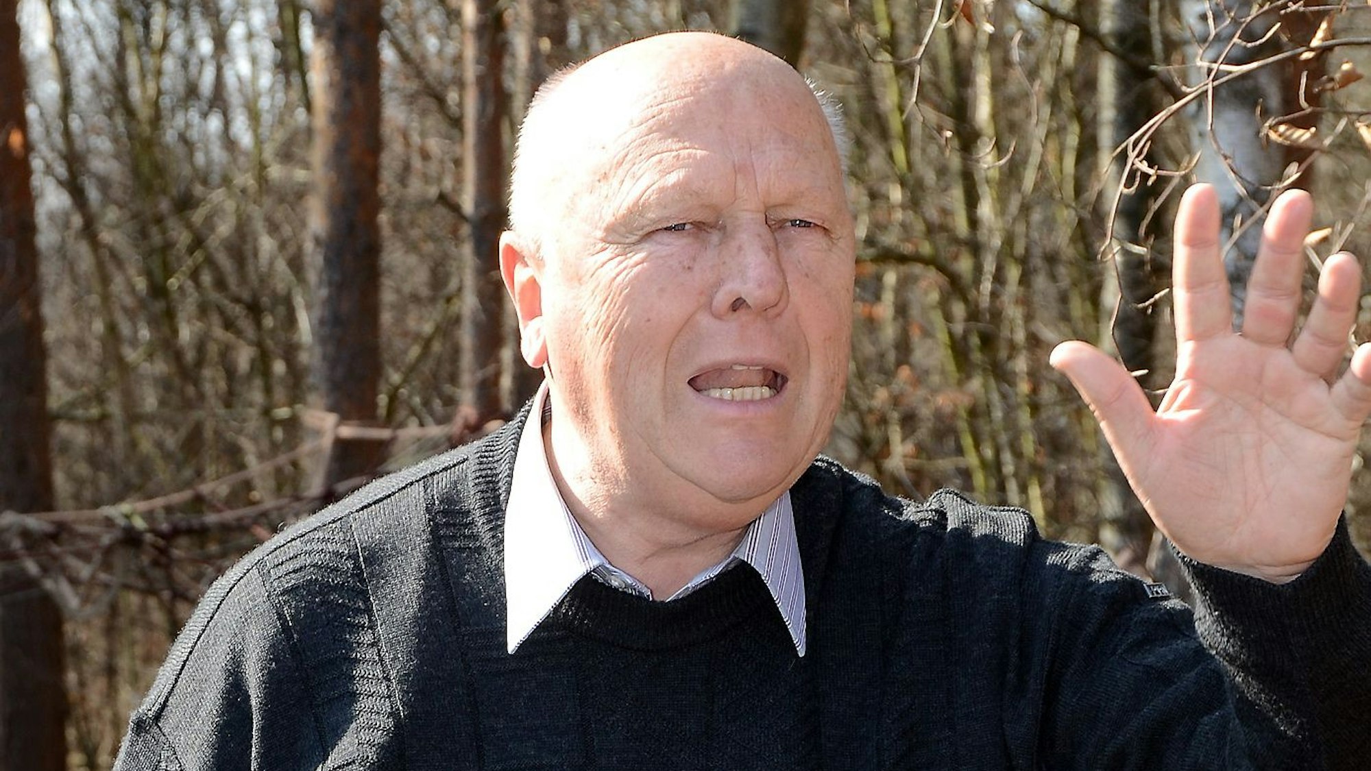 Das Bild zeigt Professor Wolfgang Schumacher bei einem Vortrag in einem Wald.