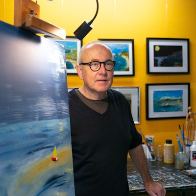 Der Künstler Achim Lahr steht neben einer Leinwand in seinem Atelier in Engelskirchen.