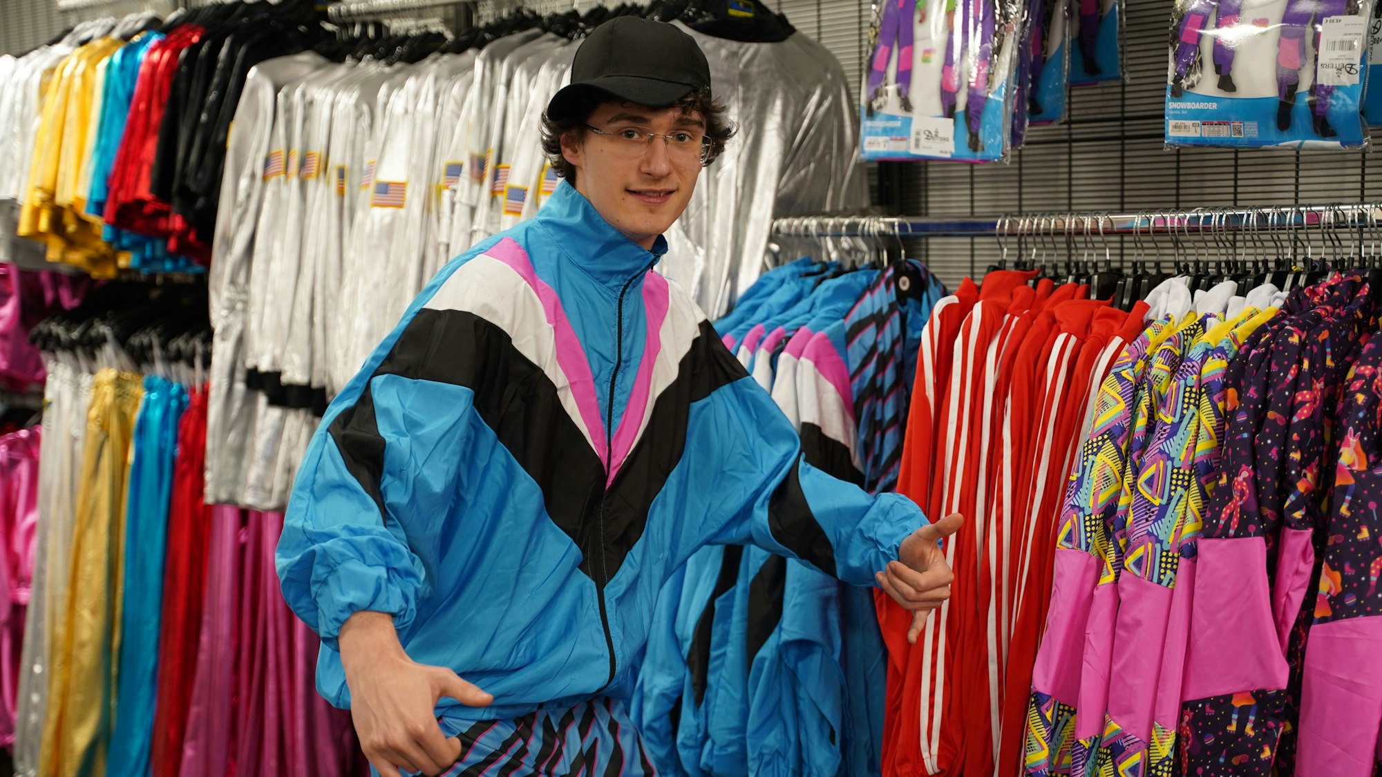 Geht immer wieder: Ein Trainingsanzug wie aus den 80er-Jahren. Oder schlichte Outfits in Metallic-Optik, die im Hintergrund zu sehen sind.
