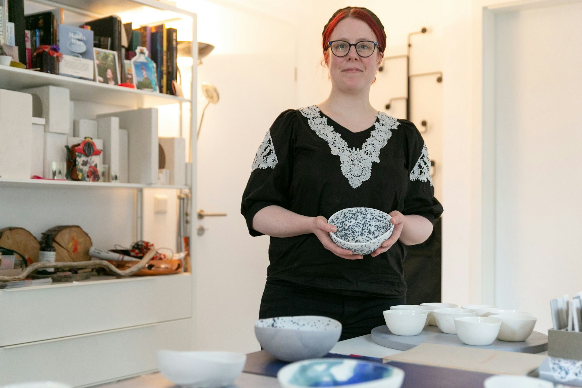 Porzellanmalerin Constanze Kleinbichler hält eine Vase in Händen.