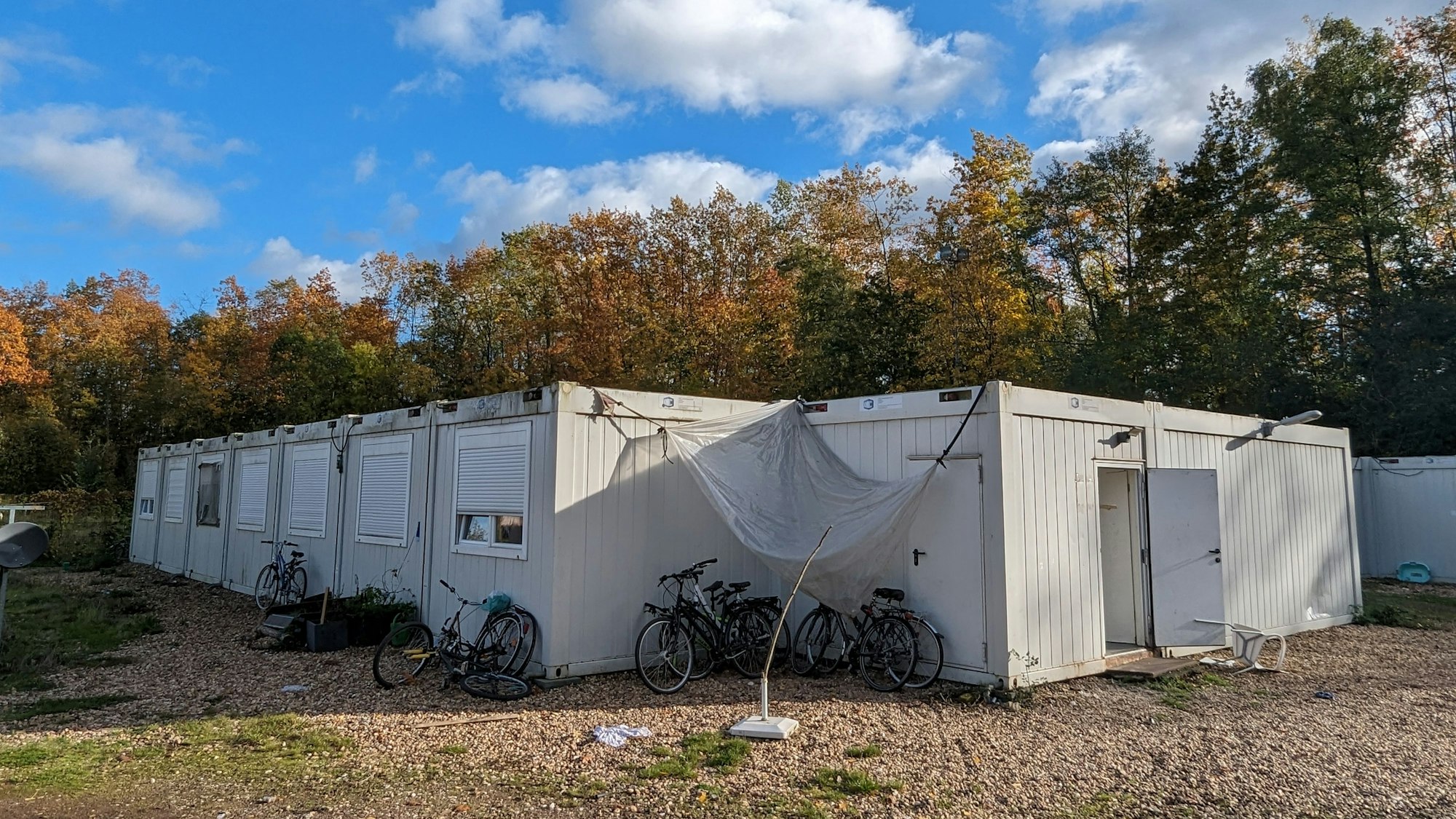 Fahrräder vor einer Wohncontaineranlage auf einem ehemaligen Sportplatz.