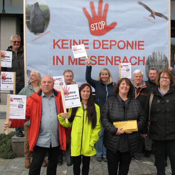 Zwölf Männer und Frauen halten Schilder und ein großes Transparent hoch, auf dem steht: Stop, keine Deponie in Meisenbach.