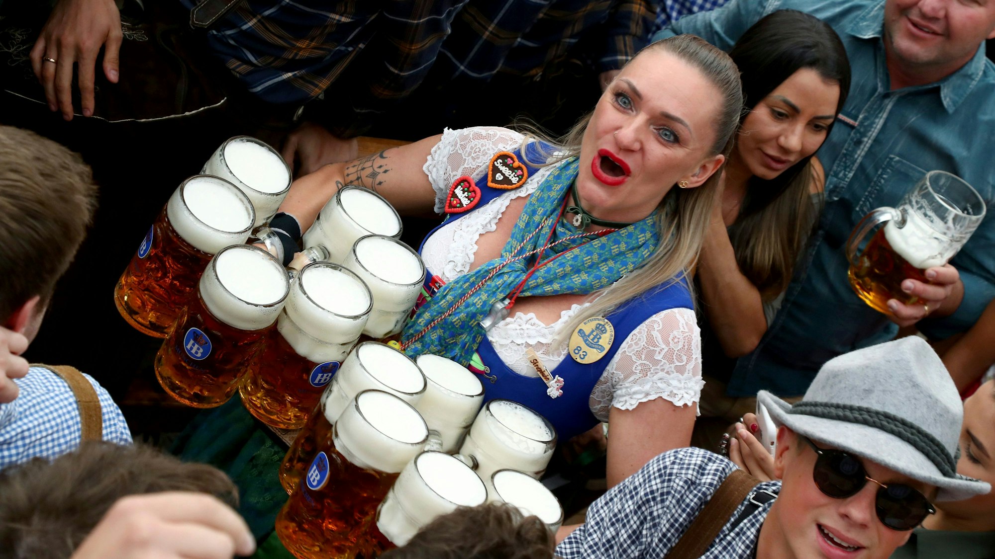 Eine Kellnerin verteilt zwölf Maß Bier auf dem Oktoberfest.