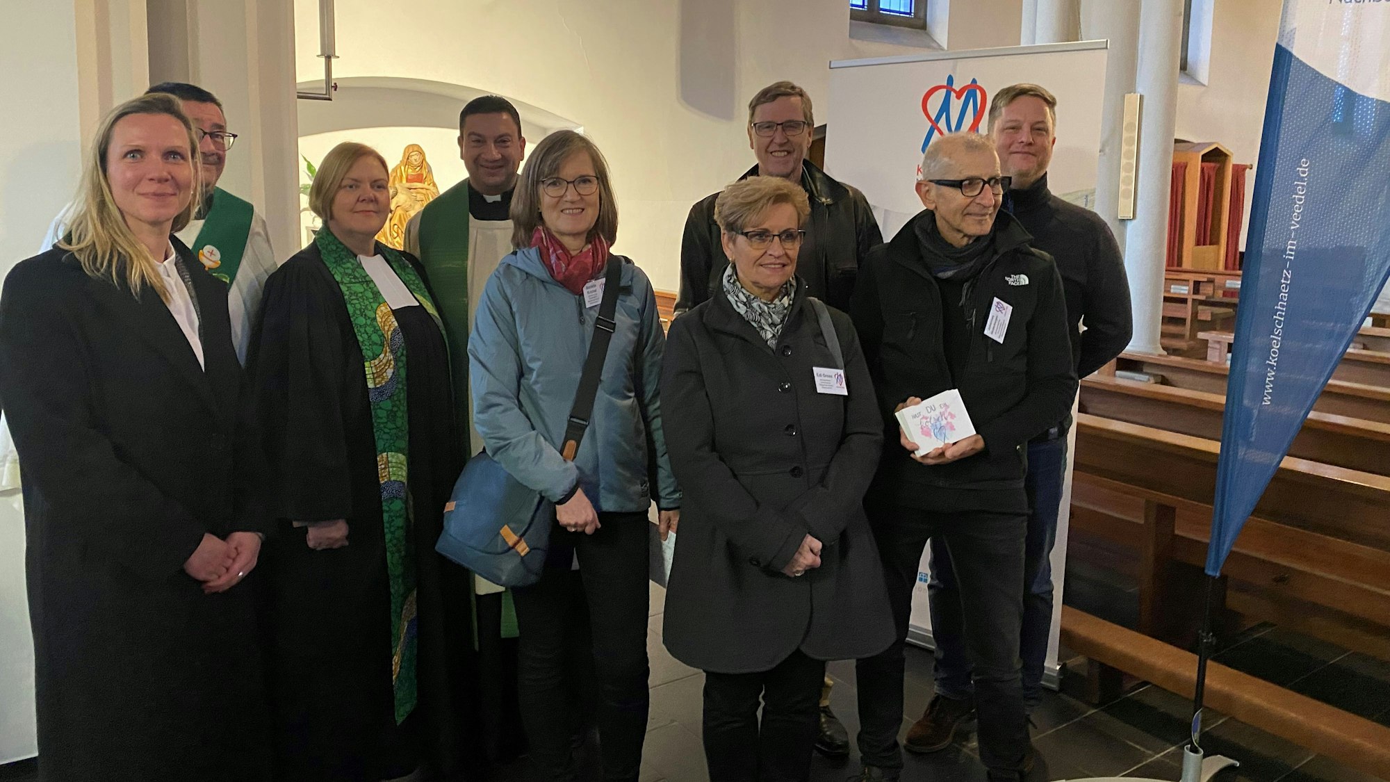 Viele Menschen stehen in einer Kirche.