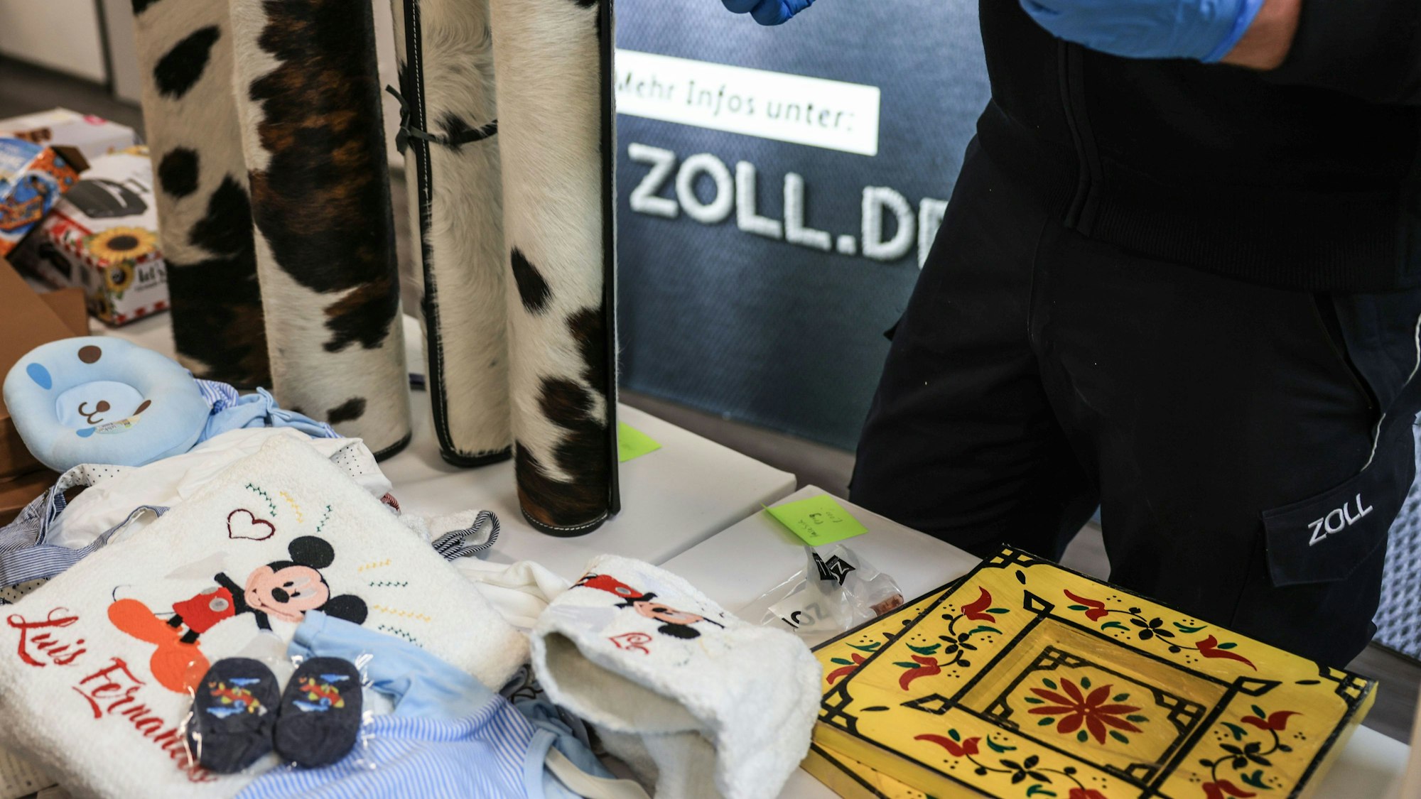 Ein Mitarbeiter des Hauptzollamtes Köln zeigt ein Drogentestgerät hinter verschiedenen Drogenverstecken.