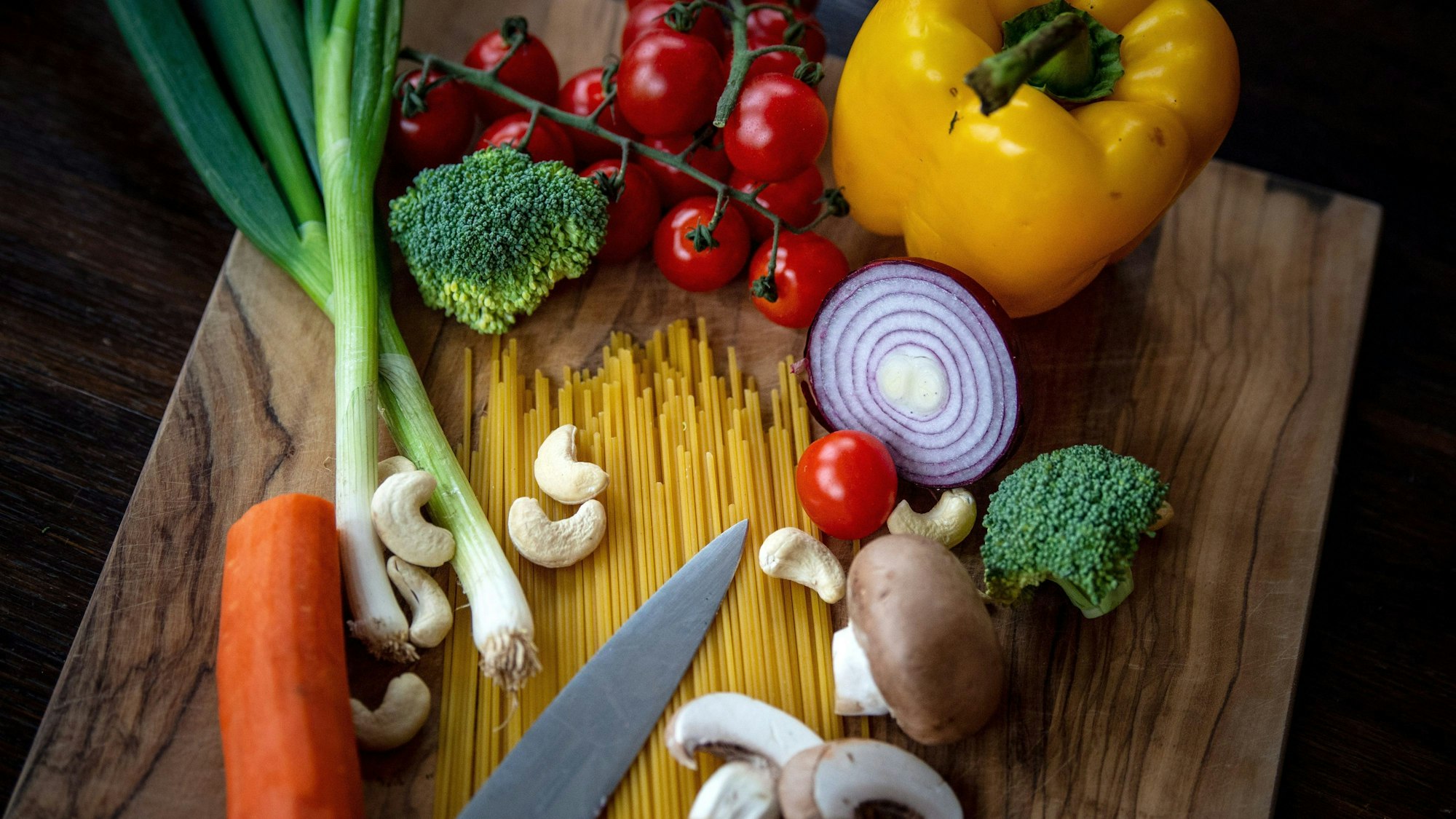 Zutaten für ein veganes Gericht liegen auf einem Brett.