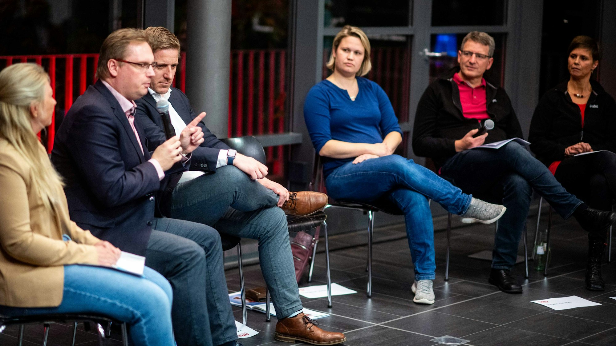 Das Bild zeigt die Diskussionsrunde in der Tuchfabrik. Gerade spricht Dennis Melzer.