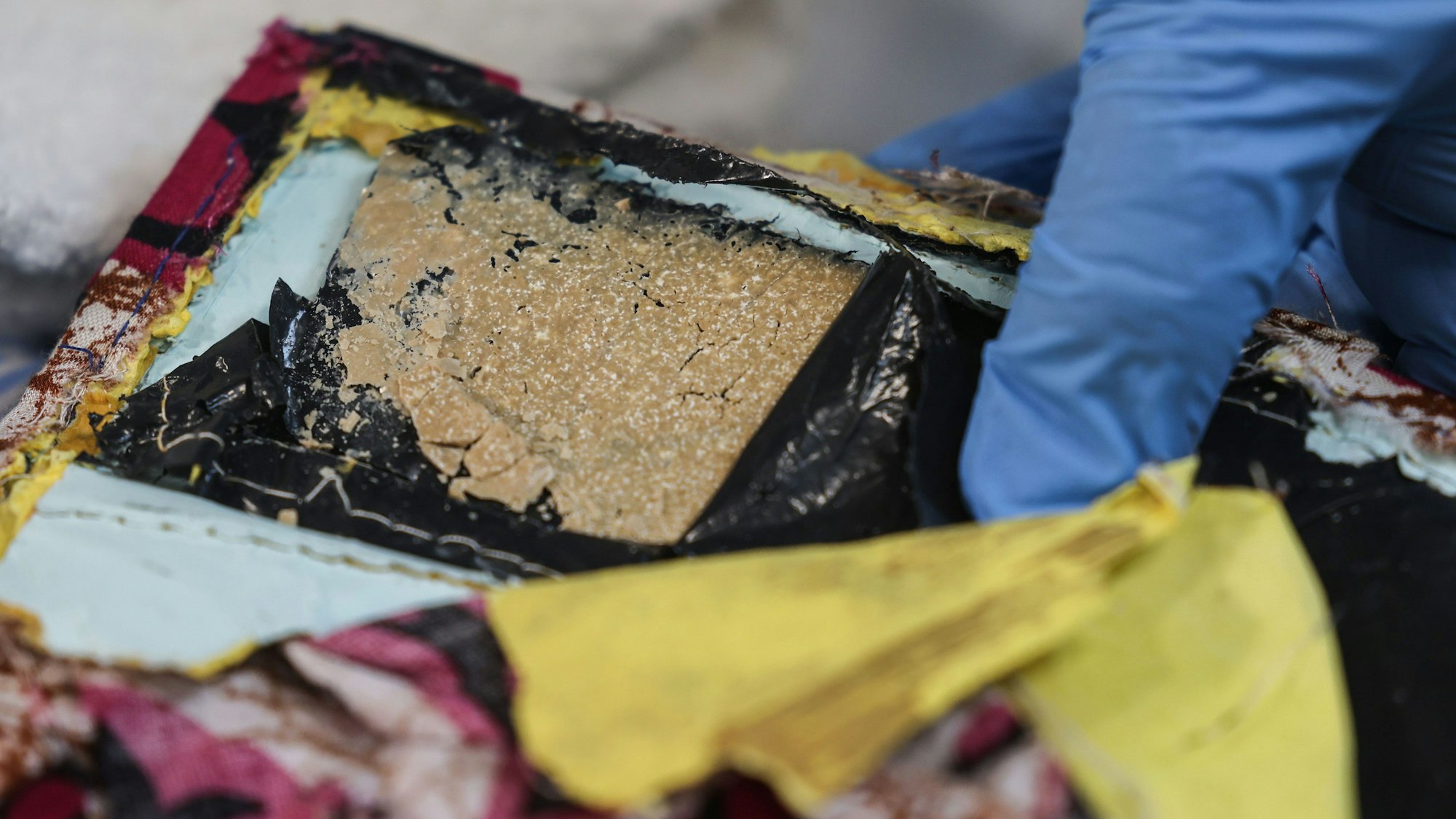 Ein Mitarbeiter des Hauptzollamtes Köln zeigt ein Drogenversteck mit Heroin, das in eine Stofftasche eingenäht wurde.