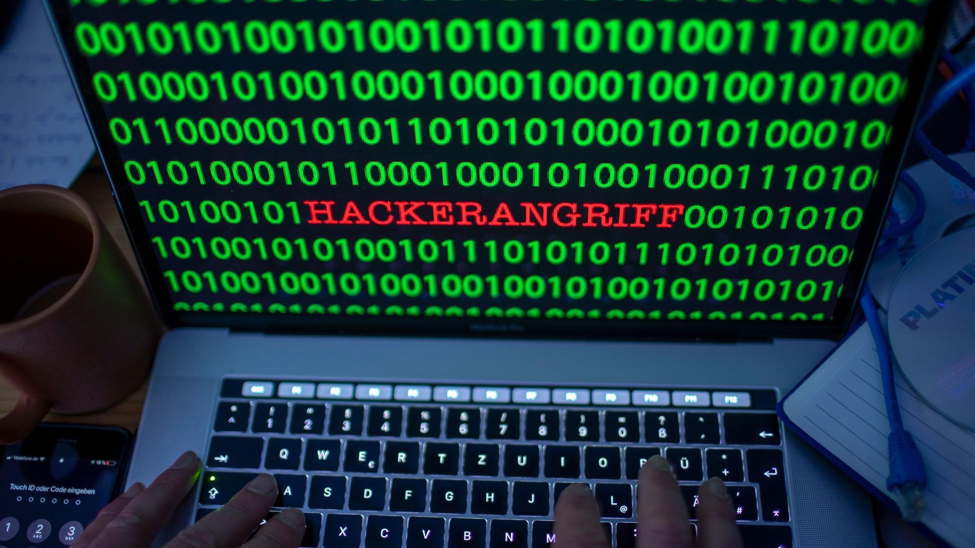 Zwischen dem Binärcode auf einem Laptopmonitor ist das Wort «Hackerangriff» zu sehen. (gestelltes Foto).