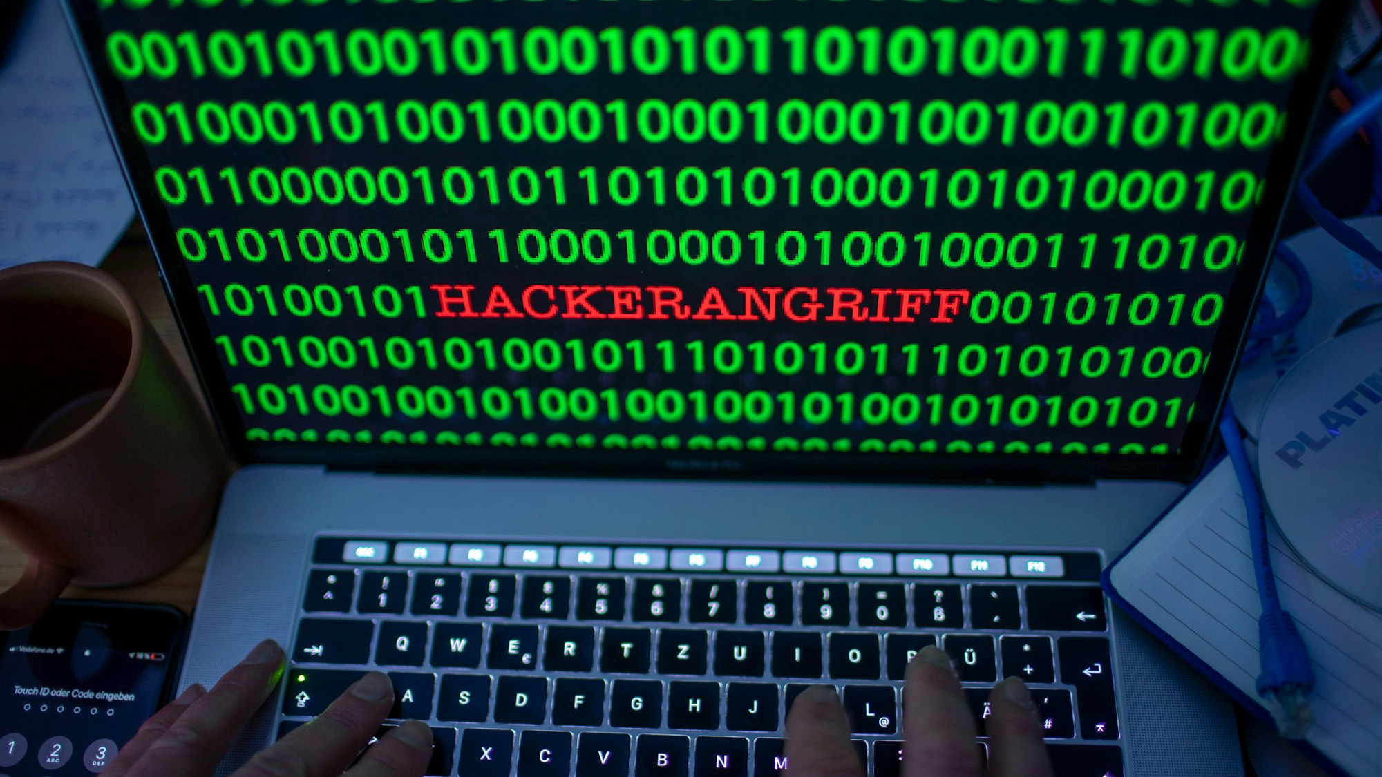 Zwischen dem Binärcode auf einem Laptopmonitor ist das Wort «Hackerangriff» zu sehen. (gestelltes Foto).