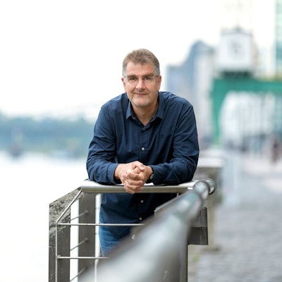 Jürgen Wiebicke lehnt sich auf ein Geländer und guckt in die Kamera.