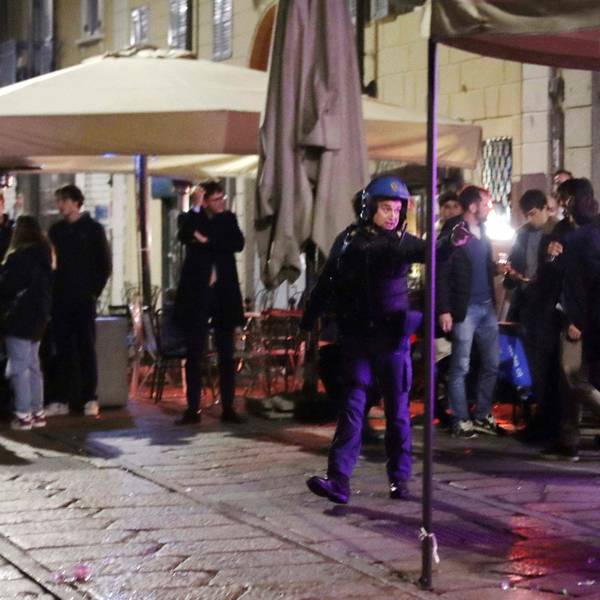 Ein italienischer Polizist ist nach den Krawallen in Mailand um Ordnung bemüht.
